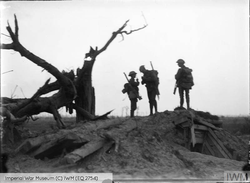 THE BATTLE OF PASSCHENDAELE, JULY-NOVEMBER 1917 (Q 2754) Three soldiers in trench kit lighting cigarettes. Pilckem, 22nd August 1917. Copyright: © IWM. Original Source: http://www.iwm.org.uk/collections/item/object/205079509
